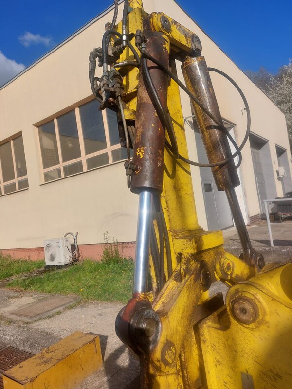 Opotřebené a korodované hydraulické válce lafety vrtné soupravy před opravou.
