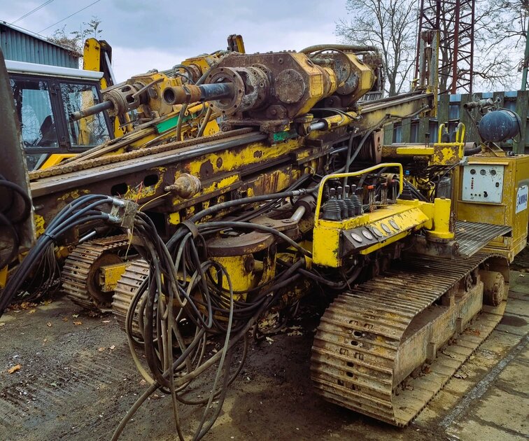Vrtná souprava HVS 6132 v původním stavu před zahájením opravy, silně opotřebená hydraulika a kabeláž.
